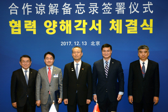 지난 13일(현지시간) 중국 베이징 댜오위타이에서 열린 전자부품연구원(KETI)과 중국 텔레매틱스 산업 응용연맹(TIAA)의 차량용 통신기술과 관련 표준플랫폼 개발을 위한 업무협약(MOU)식에서 (왼쪽부터)김준동 대한상공회의소 부회장, 박청원 KETI 원장, 백운규 산업통상자원부 장관, 우젠회 중국 TIAA 이사장, 천저우 CCPIT(중국국제무역촉진위원회) 부회장이 포즈를 취하고 있다. <KETI 제공>